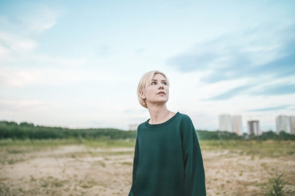 beautiful-pensive-blonde-woman-looking-up-at-cloud-2022-12-16-15-57-36-utc